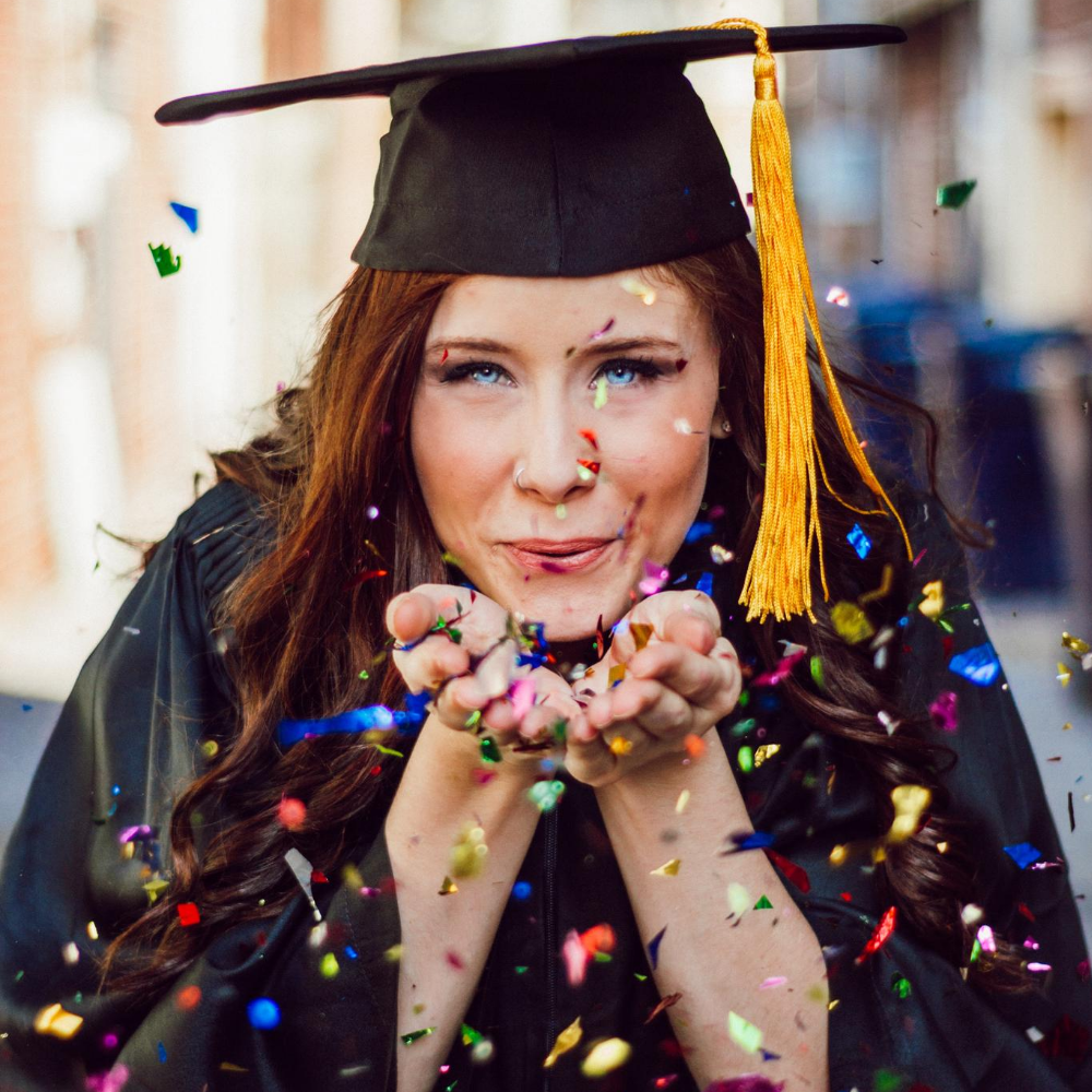 Graduate blowing confetti image